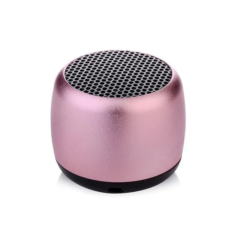 A compact rose gold metallic bluetooth speaker portable with black perforated grille and base for mobile music