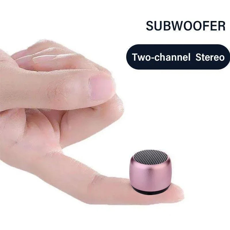 A compact rose gold metal wireless loudspeaker bluetooth speaker portable with mesh grille and black base for music