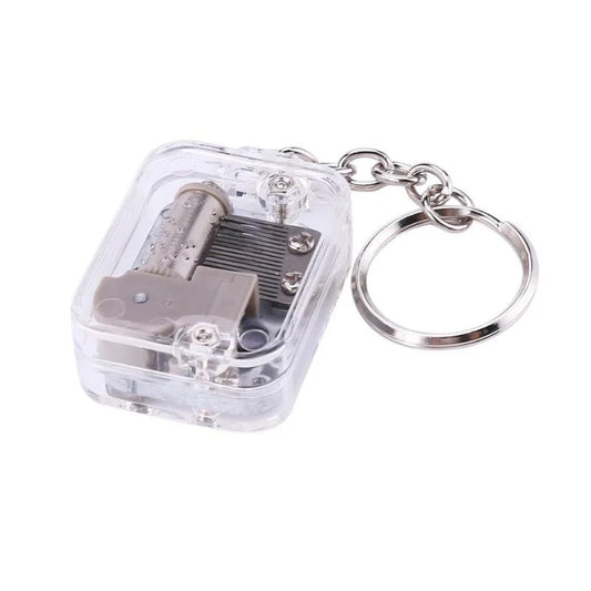Clear plastic keychain housing a miniature silver best mechanical metal music box movement with 18 tones clockwork music mechanism