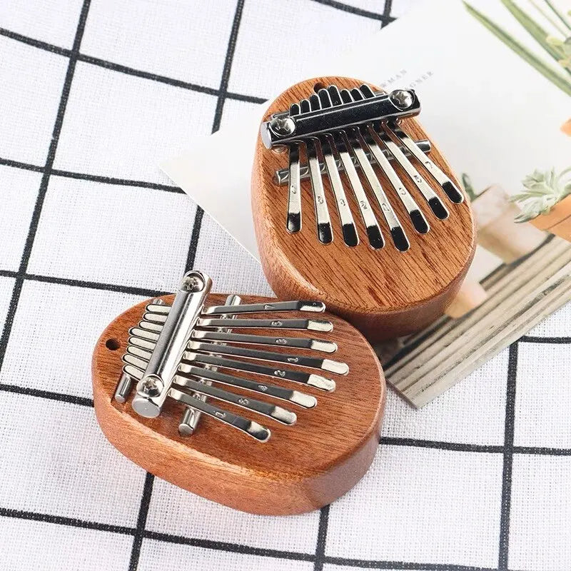 Wooden-bodied thumb piano musical toy with silver metal tines and black tuning pegs for tones portable beginner use