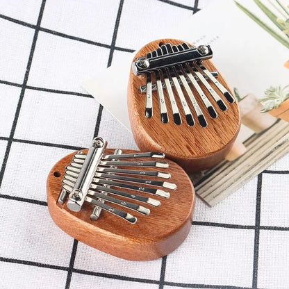 Wooden-bodied thumb piano musical toy with silver metal tines and black tuning pegs for tones portable beginner use