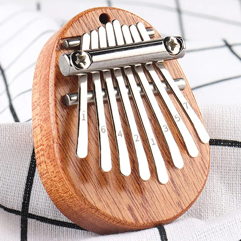 A wooden thumb piano musical toy with silver metal tines and engraved numbers 8 tones portable beginner finger piano