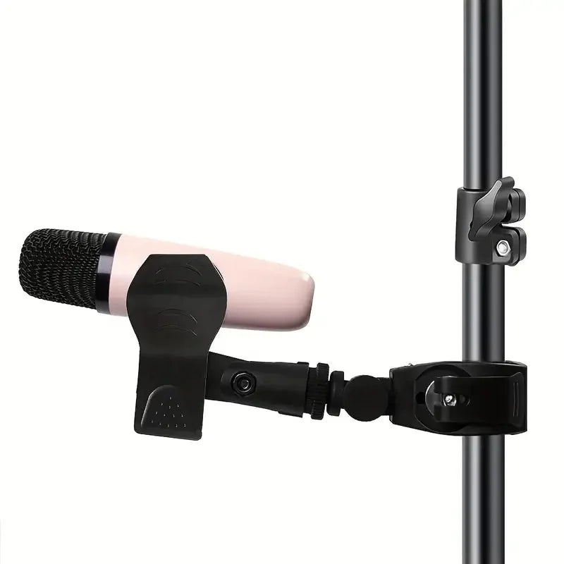 A sleek black microphone crab clamp securely holds a blush pink condenser microphone for drum rim mounting