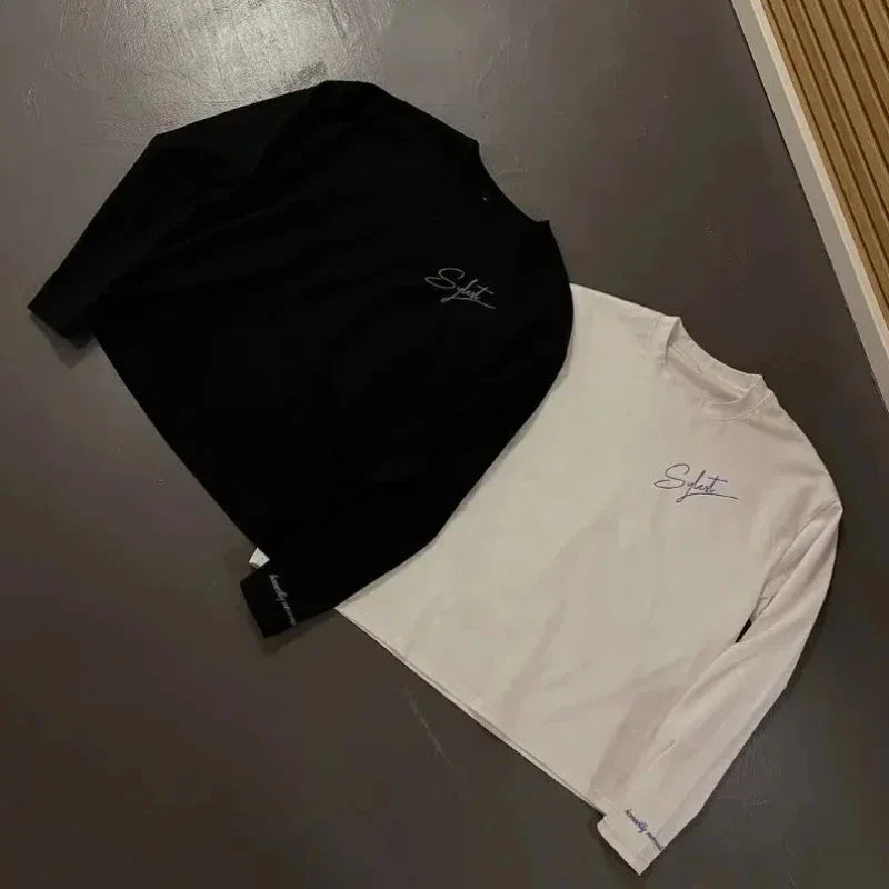 A black and white long-sleeved top with subtle embroidered signature featuring letter printing round neck for 2000s simple fashion harajuku streetwear hip look