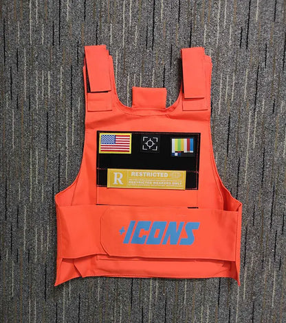 Bright orange tactical vest with blue plus icons branding and black patch featuring american flag and camera lens icon