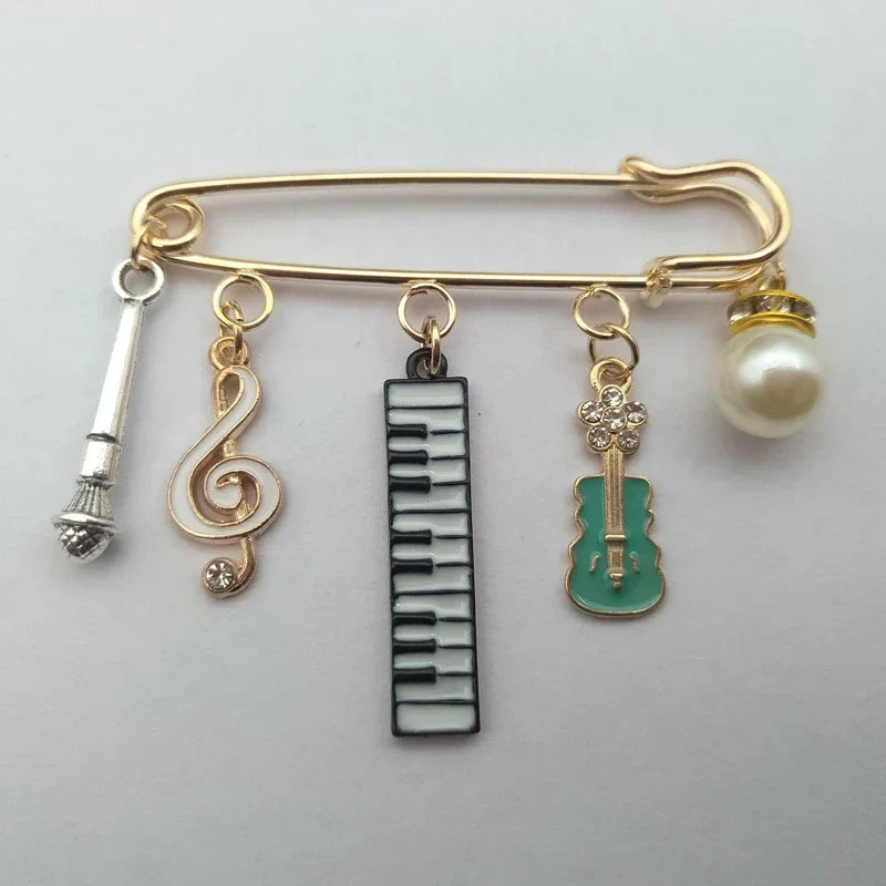 Gold-toned safety pin with silver microphone and gold treble clef charms 2022fashion collocation musical instrument guitar violin brooch pendant