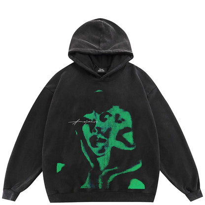 Black hoodie with bold green abstract face graphic and amojeans white script for 2023 hip hop streetwear pullover