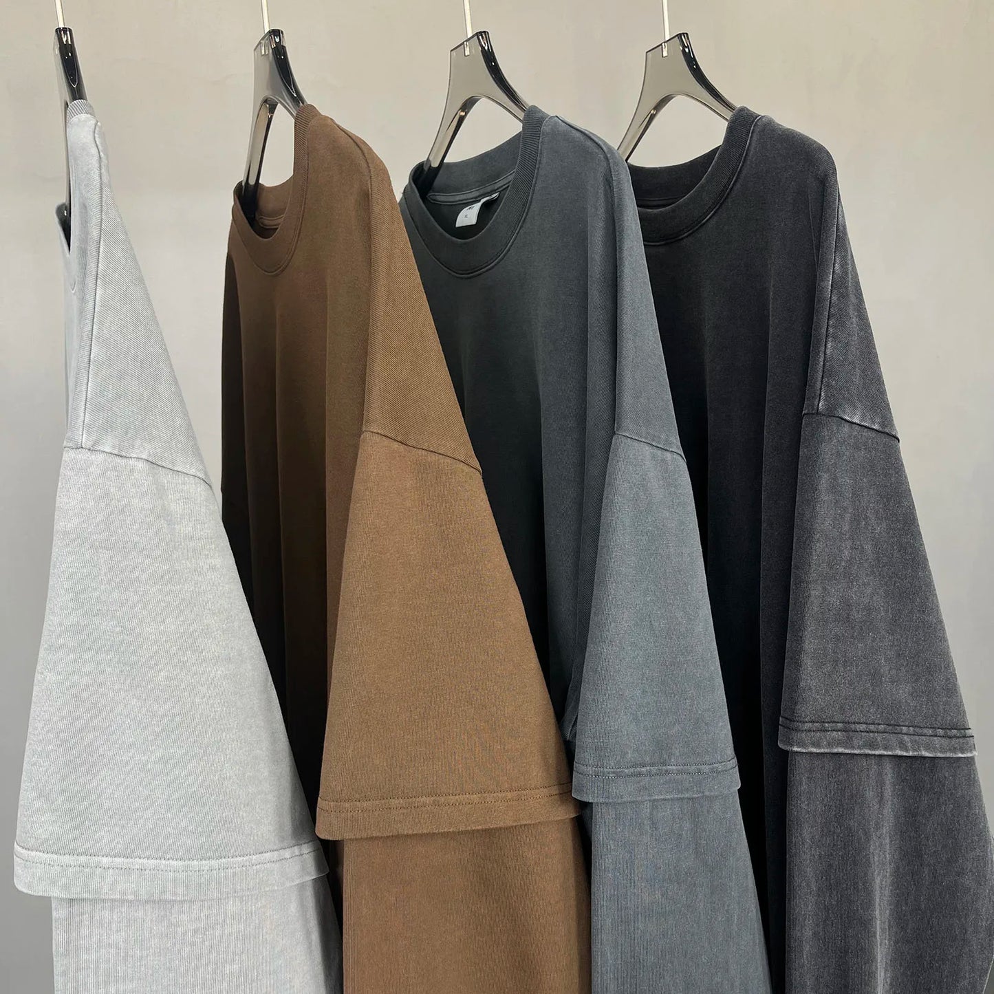Four oversized hip hop retro baggy tshirts y2k in muted gray brown and black hang on hangers for men washing streetwear