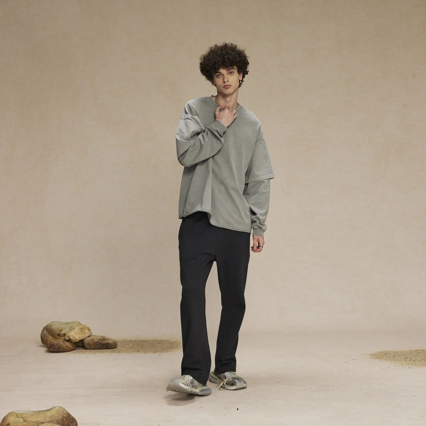 A man wearing a muted gray hip hop retro baggy tshirt y2k with oversized collar and side slits for men washing streetwear