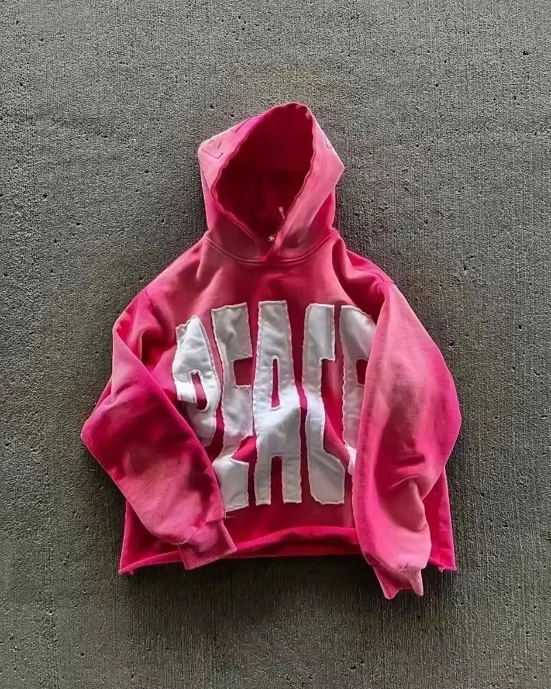 A vibrant pink cropped sweater men y2k with bold white peace lettering in y2k gothic harajuku fashion oversized pattern style