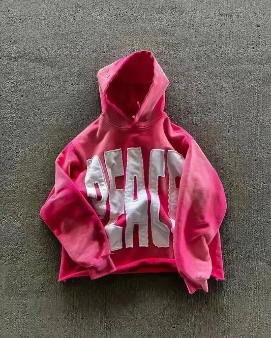 A vibrant pink cropped sweater men y2k with bold white peace lettering in y2k gothic harajuku fashion oversized pattern style