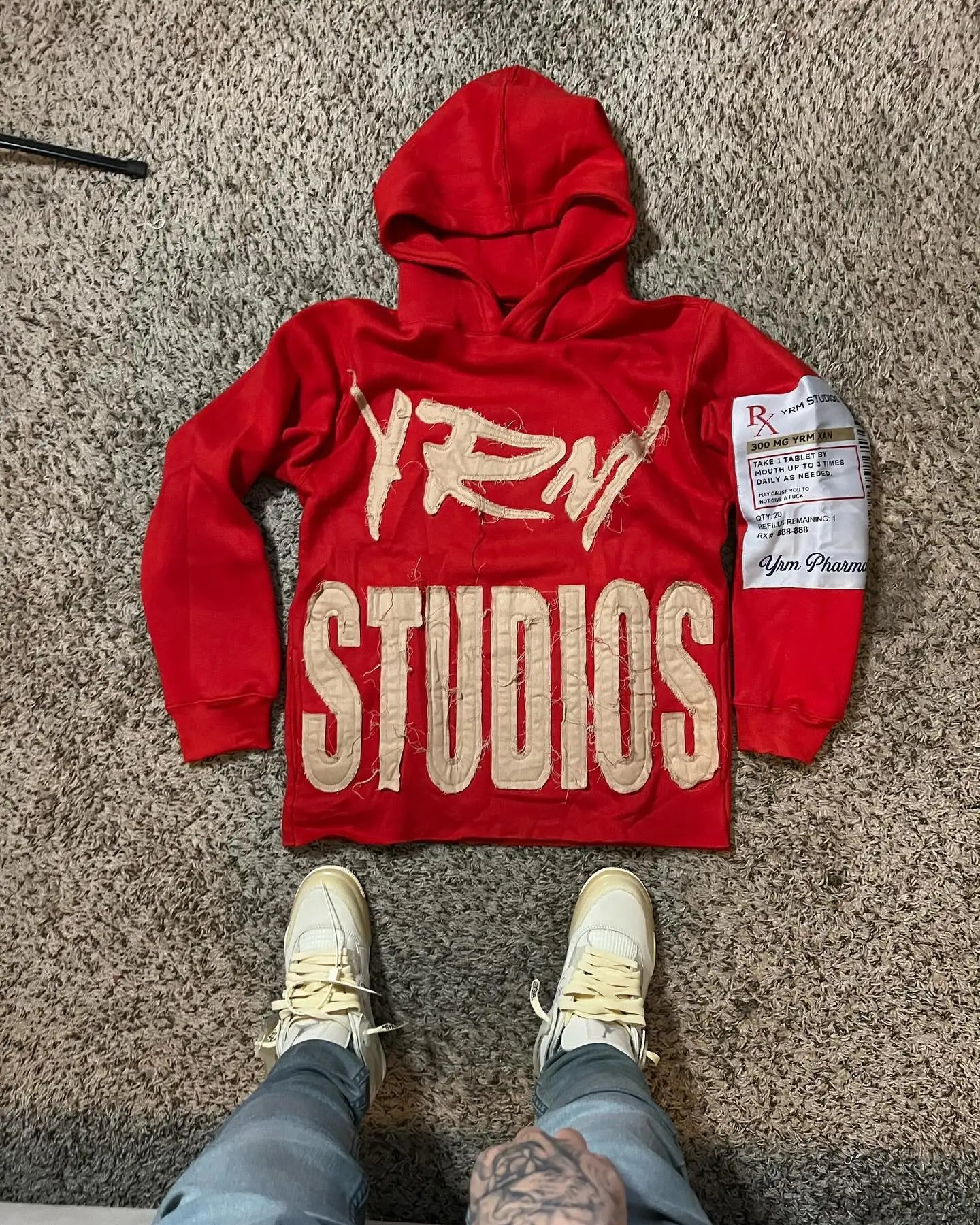Red hooded sweatshirt men y2k with beige graffiti yrn, blocky studios text, and yun pharm patch on left sleeve