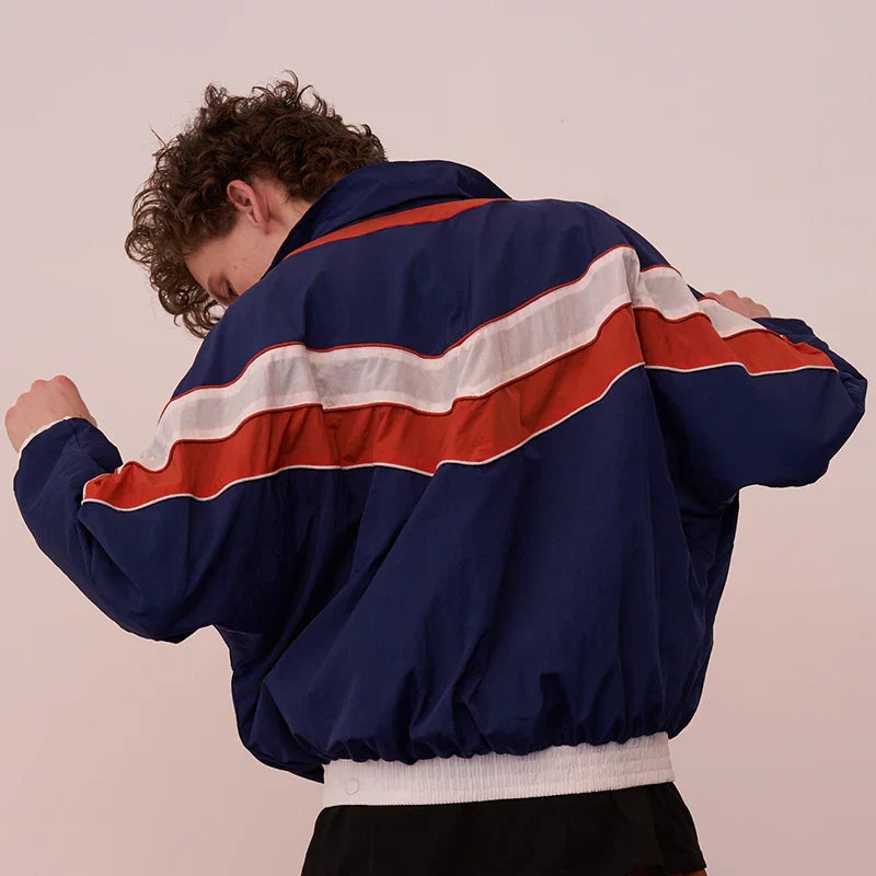 Back view of blue hip hop jacket with bold red and white diagonal stripes in windbreaker retro streetwear style coat autumn harajuku