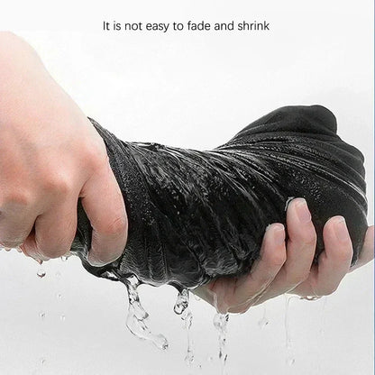Black cotton hip hop shirt streetwear garment held and squeezed with water dripping from its wet surface
