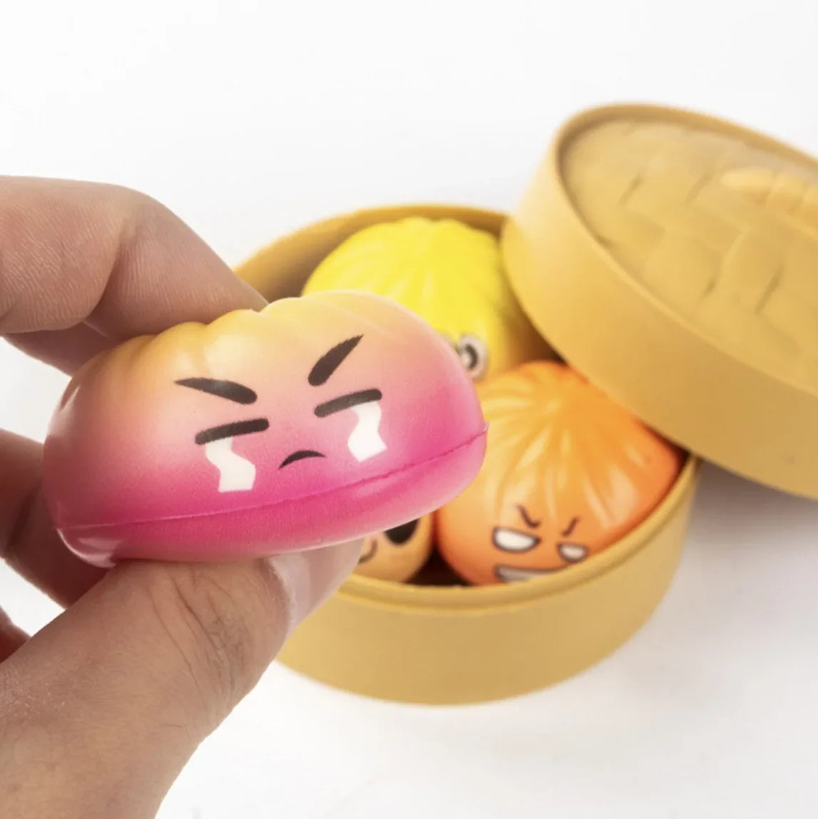 A pink and orange gradient stress ball with a crying angry face for stress relief and kneading play in 2026 design