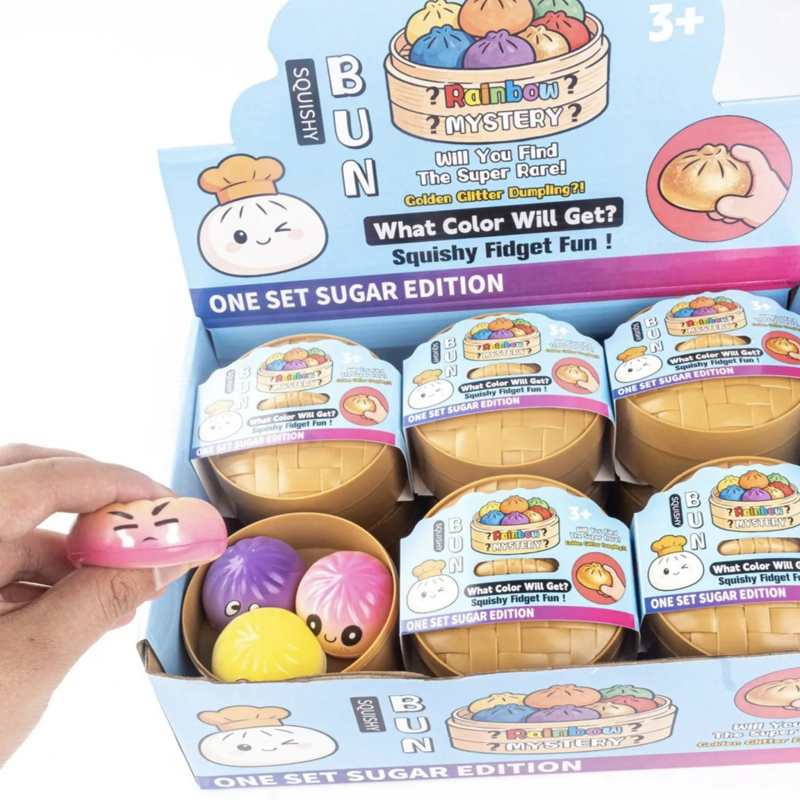 A pink glossy squishy baozi stress relief toy with a cartoon face for venting and kneading simulation in 2026