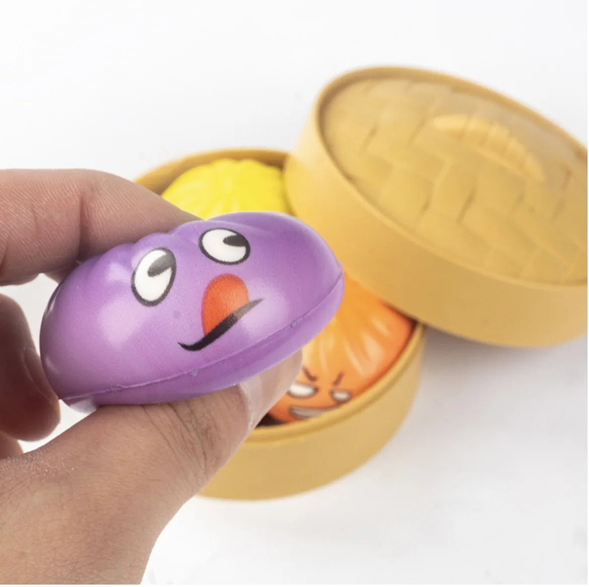 Purple oval-shaped baozi stress ball with cartoon eyes and smiling mouth for decompression and stress relief play