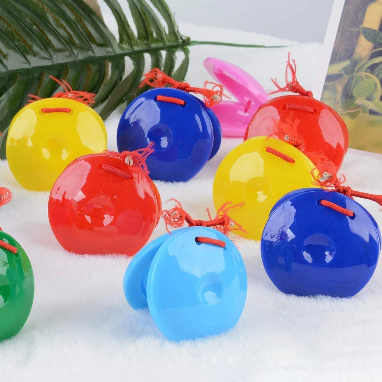 Brightly colored glossy plastic finger castanets rhythm with red string ties preschool musical percussion toys