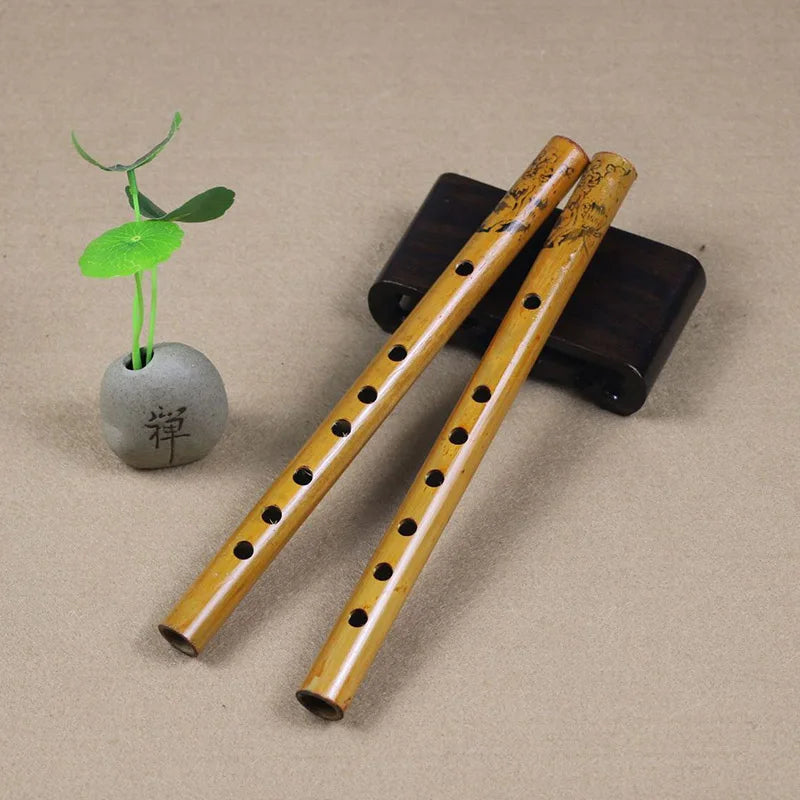 Two hand-carved light golden 24cm chinese traditional 6 holes bamboo flutes with dark engravings on a black stand for clarinet student elementary use