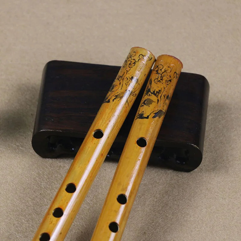 Two intricately carved 24cm chinese traditional yellow bamboo holes flute on dark wooden stand for clarinet student elementary use