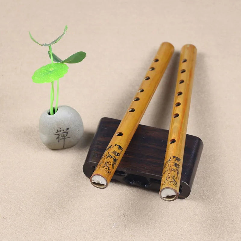 Two light brown 24cm Chinese traditional 6 holes bamboo flutes with black engravings on a dark wooden stand for clarinet student elementary use