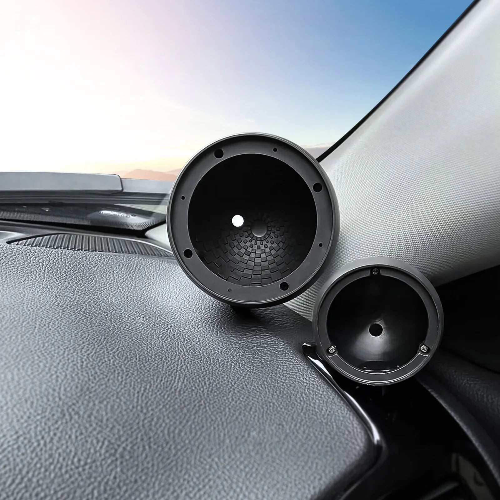 Black circular car mid-to-high-range speaker enclosures with textured inner surfaces and mounting holes rear view