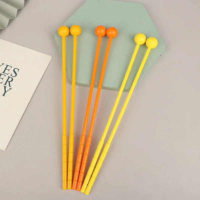 Set of four colorful plastic percussion drum sticks with yellow and orange rounded heads for adults and kids