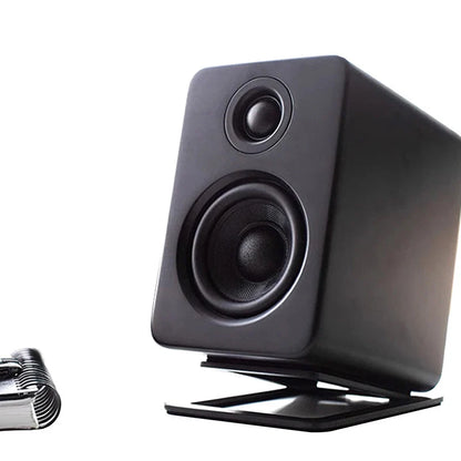 Black rectangular studio monitor speaker with two drivers on a desktop speaker stand for enhanced sound and shock absorption