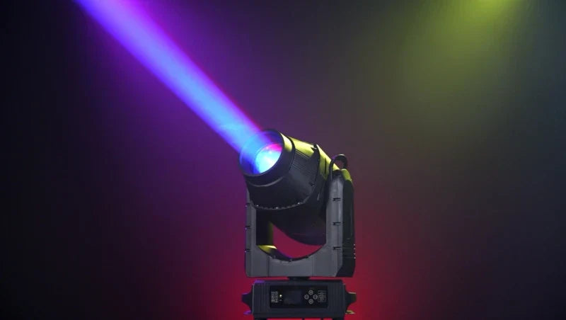A black and gray flycase megapointe ip66 580w head light outdoor emitting a vibrant blue purple beam of light