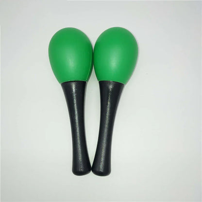 A pair of vibrant green plastic maracas sand with black handles used as hammer rattle shaker percussion musical instruments