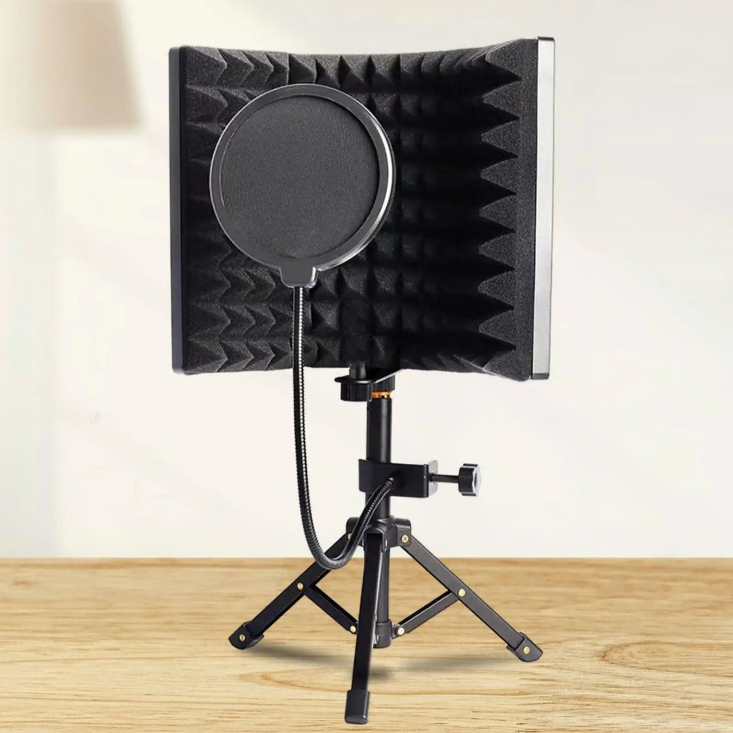 Black foam microphone isolation shield with circular pop filter mounted on tripod stand for vocal recording panel