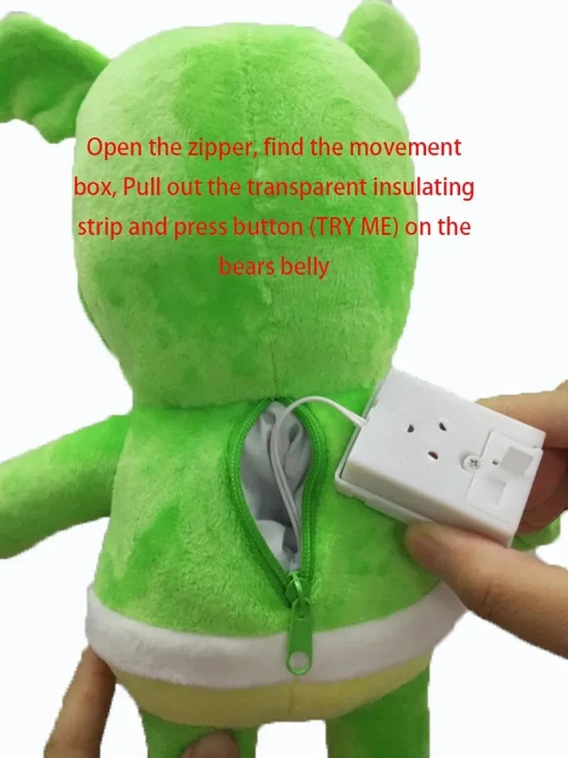 Back side of 30cm green singing gummy plush bear with zipper revealing white electrical plug in internal compartment