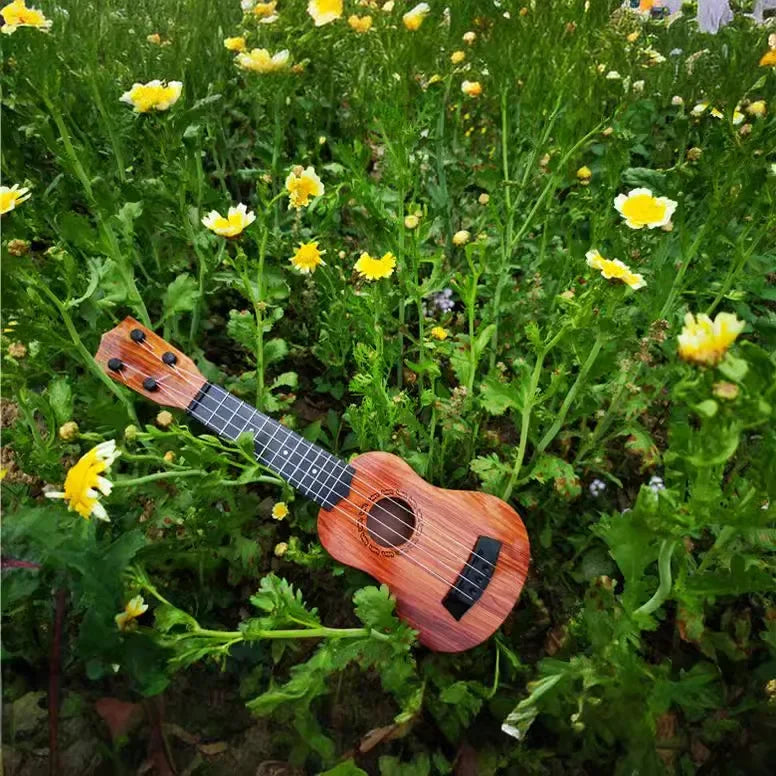 A 35cm ukulele children toy with warm brown wooden finish and paddles simulating yukrili among foliage and flowers