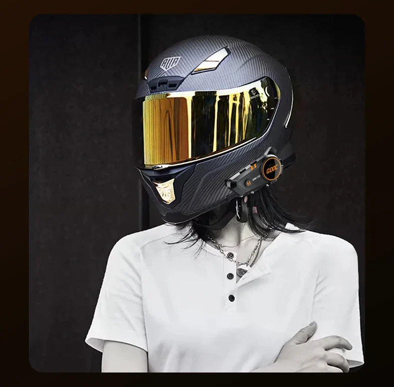 Black carbon fiber bass motorcycle helmet with gold-tinted visor and integrated headset stereo bluetooth system