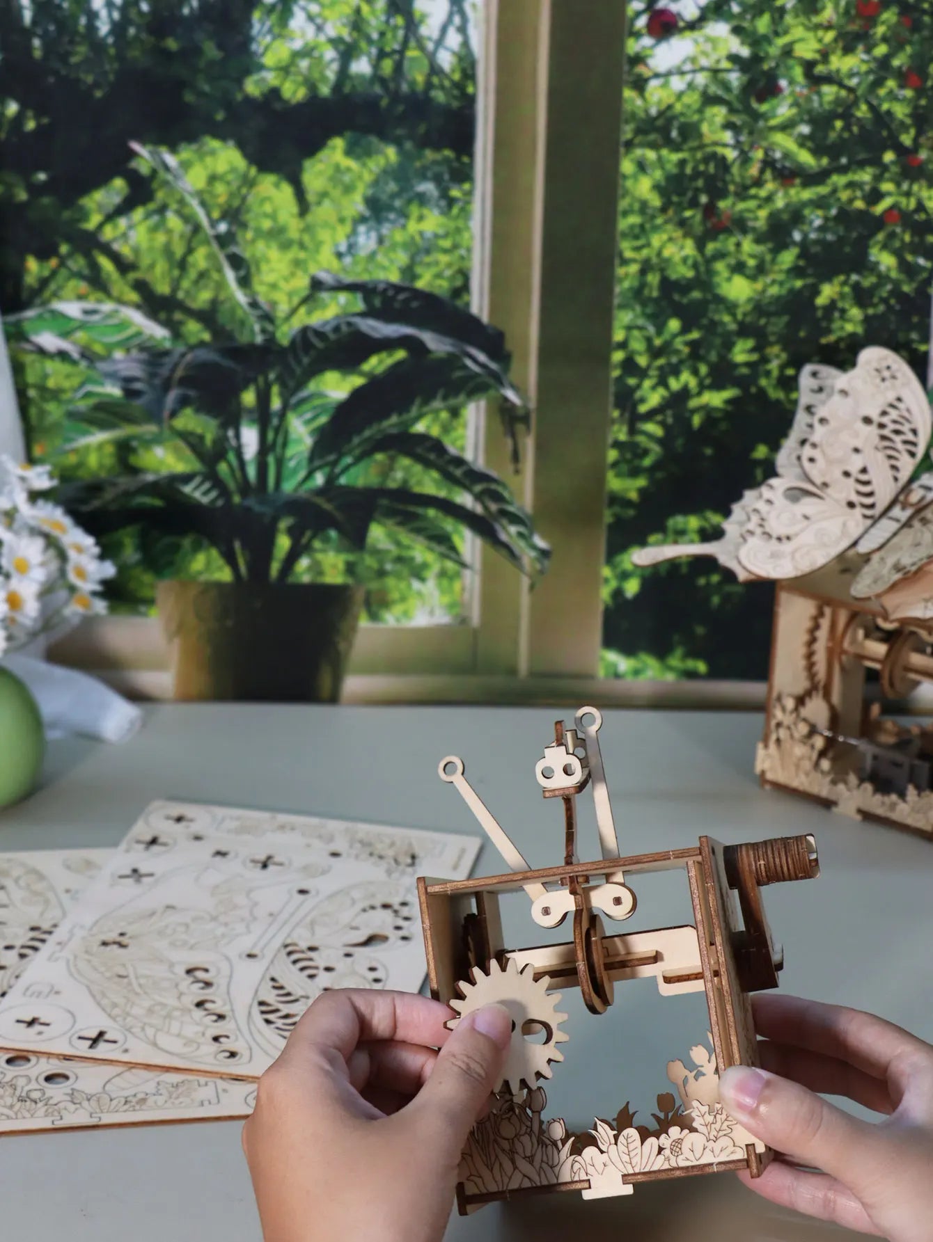 A light-colored wooden 3d puzzle hand butterfly music box with intricate gears and sunshine handmade assembly model kit