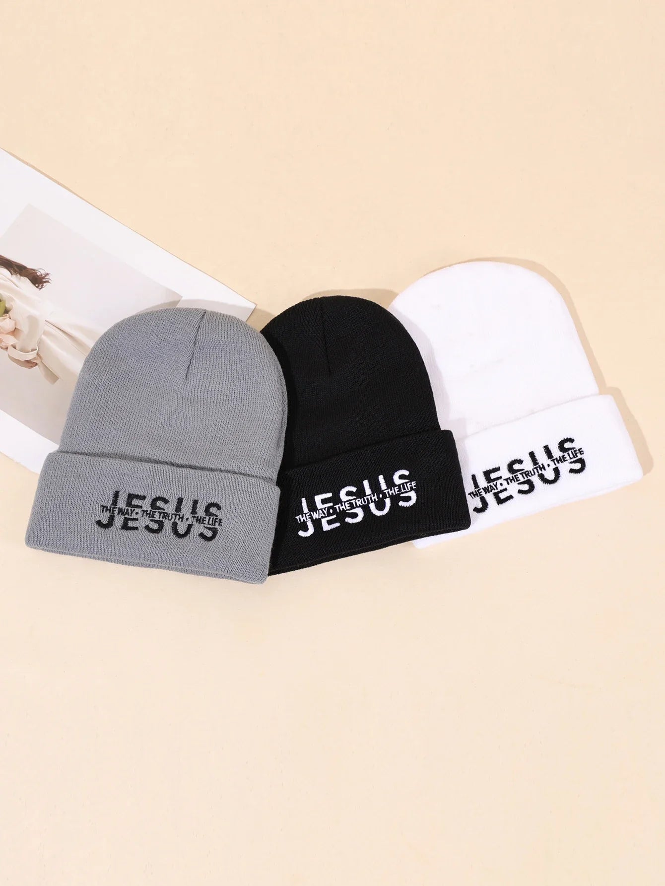 Three warm knitted beanie hats in gray black and white with jesus embroidered on cuff for autumn winter use