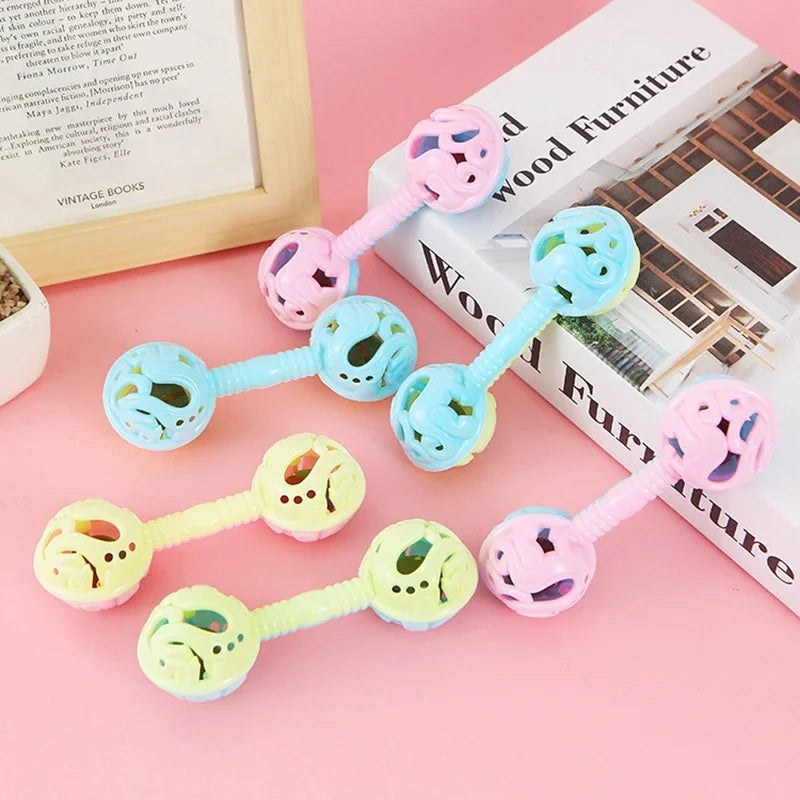 Pastel-colored plastic double-headed small toy rattle with perforated ends and smooth handles for toy baby shower or holding bell gift