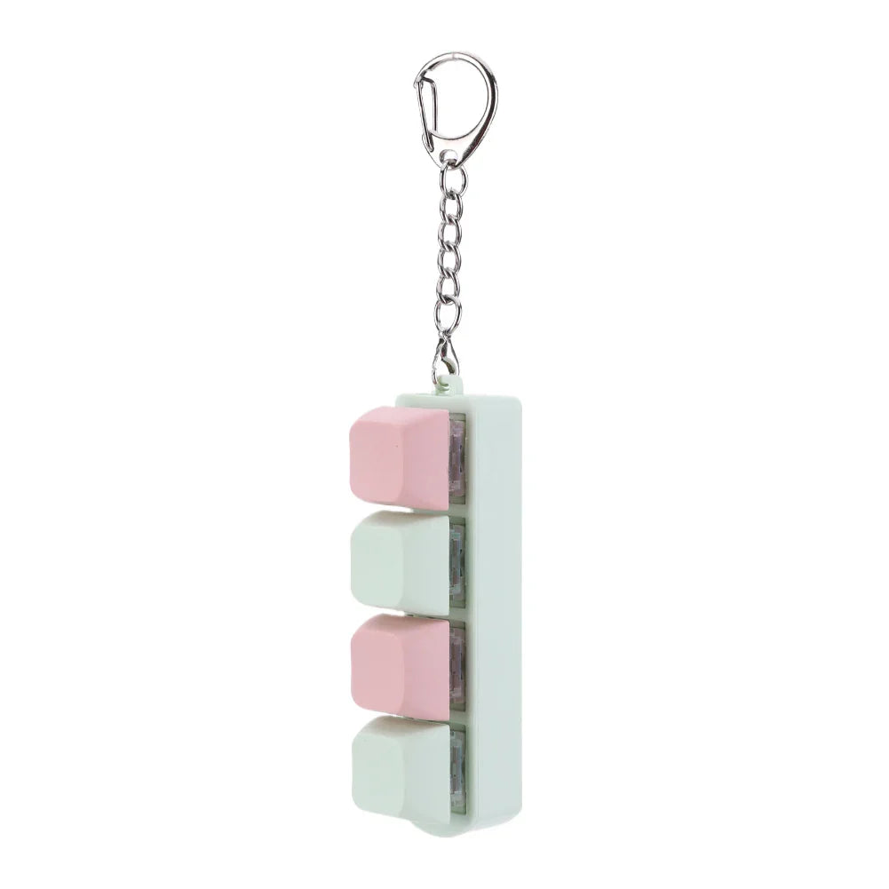 Pastel pink and mint green silicone keycap fidget keychain shaped like keyboard keys with metal clip for keyboard clicker toy use
