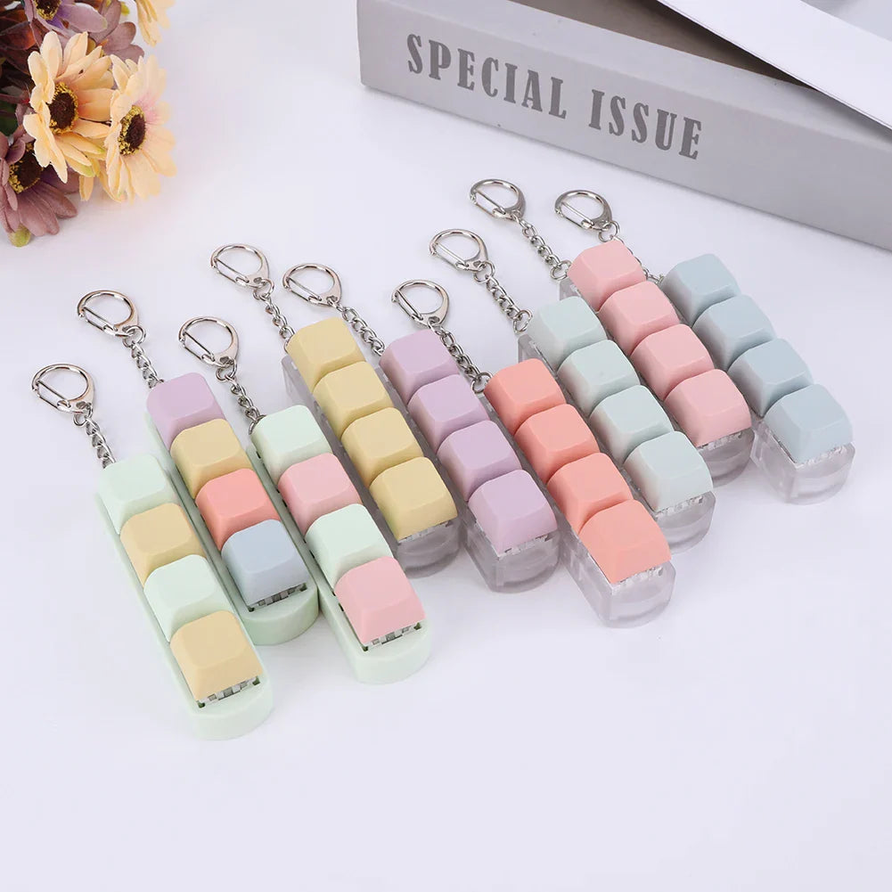 Pastel-colored silicone keycap fidget keychain staplers with clear bases and silver clasps for keyboard clicker toy use