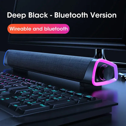 Deep black computer speaker bar with textured fabric grille and glowing purple led accents for stereo sound