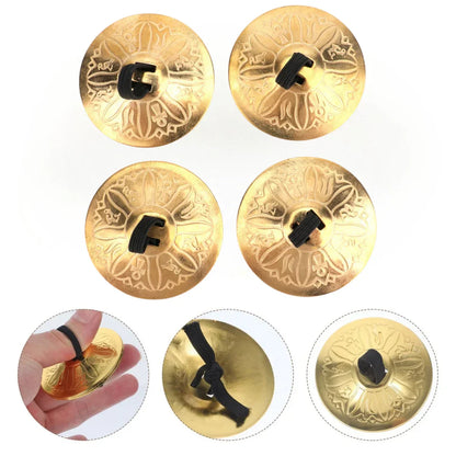 Golden copper finger cymbals with intricate floral engravings and black rubberized handles for finger cymbals belly dance