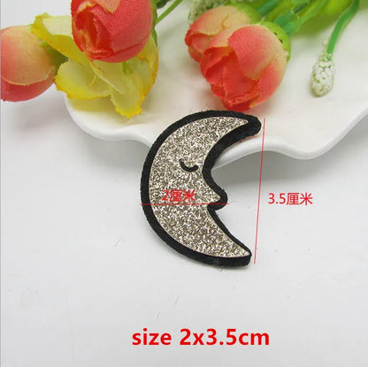 A glittery silver crescent moon sparkle patch padded with a black border and closed-eye design for applique decoration diy