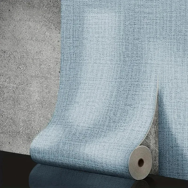 A light blue 50cm self-adhesive foam wall panel with a woven pvc texture partially unrolled on a gray wall for living room decor