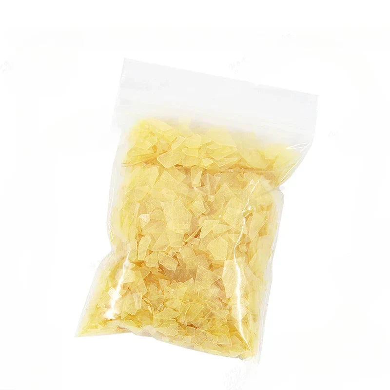 A clear plastic bag of pale yellow irregular sugar cubes 50g shellac varnish sheet for primer handmade guitar material