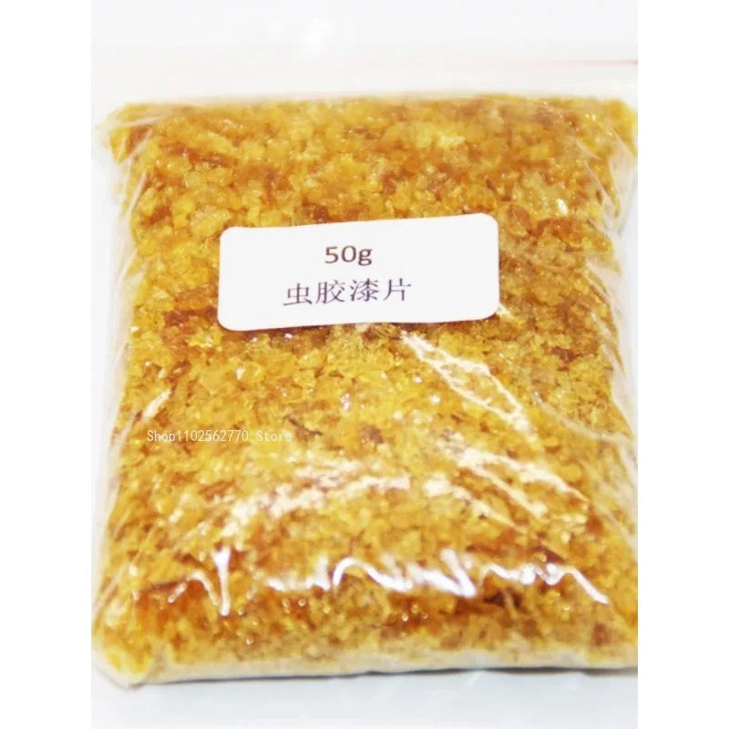 A 50g package of amber-colored translucent resin flakes for shellac varnish primer handmade guitar material use