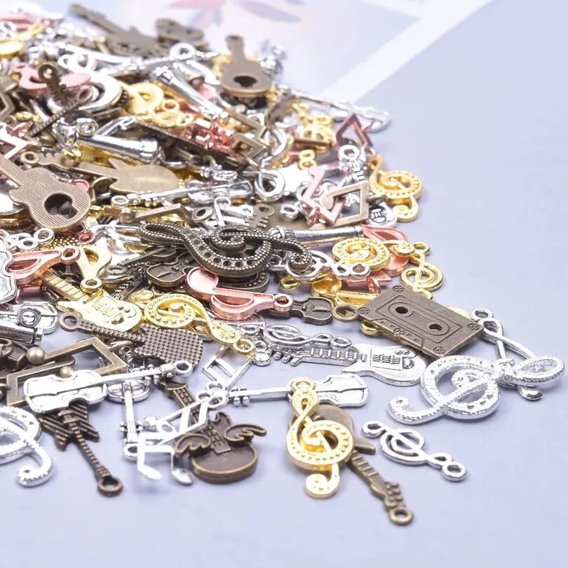 A collection of vintage random diy bulk violin guitar musical note charms in silver gold and bronze metal finishes