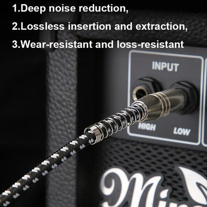 Black and white braided 6.5 to 3.5 mm audio cable with spiral connector plugged into electric guitar amplifier jack