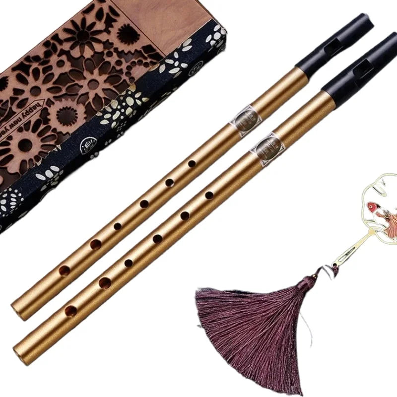 Two golden brass tin penny whistles with black mouthpieces silver bands and a purple tassel key irish whistle wind instrument