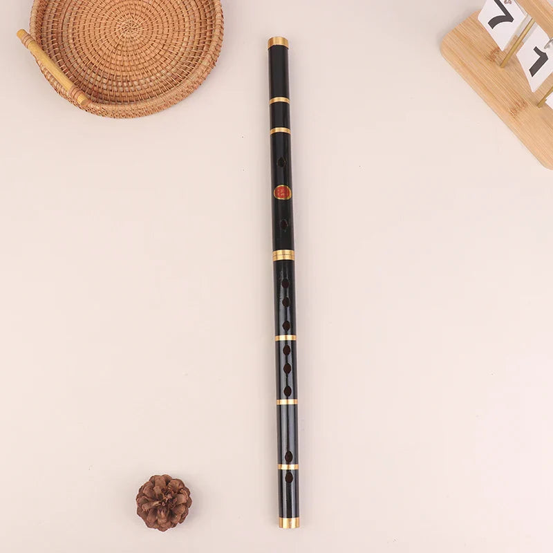 Black handmade bamboo transverse flute with six holes, gold metal rings, and red emblem for folk sound durable use