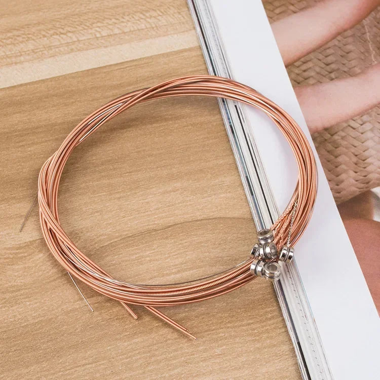 Coiled copper-colored guitar string brass with hexagonal steel core and metallic tuning pegs 6pcs set universal resting on wood